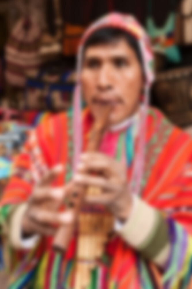 Portrait of Peruvian man playing a flute, Pisac market, Peru